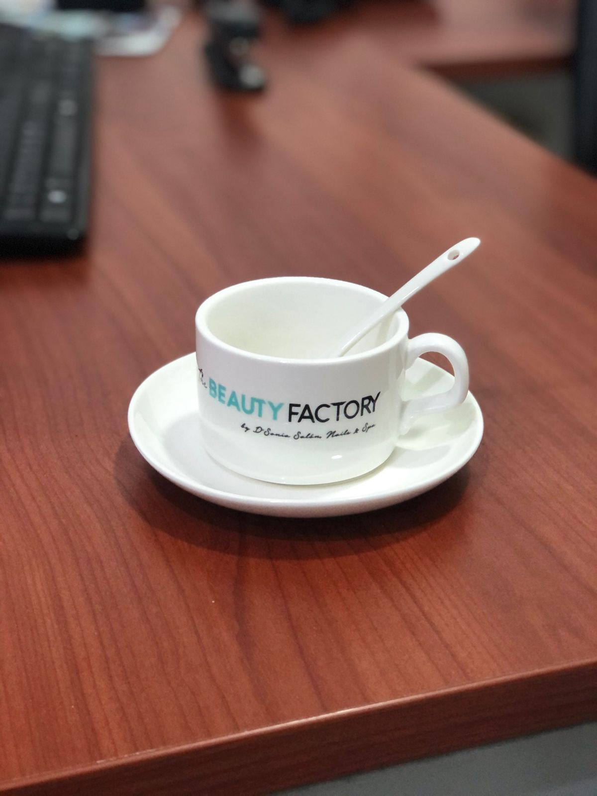 Taza cerámica blanca con logo de Beauty Factory by D'Sonia en sublimación negro y turquesa